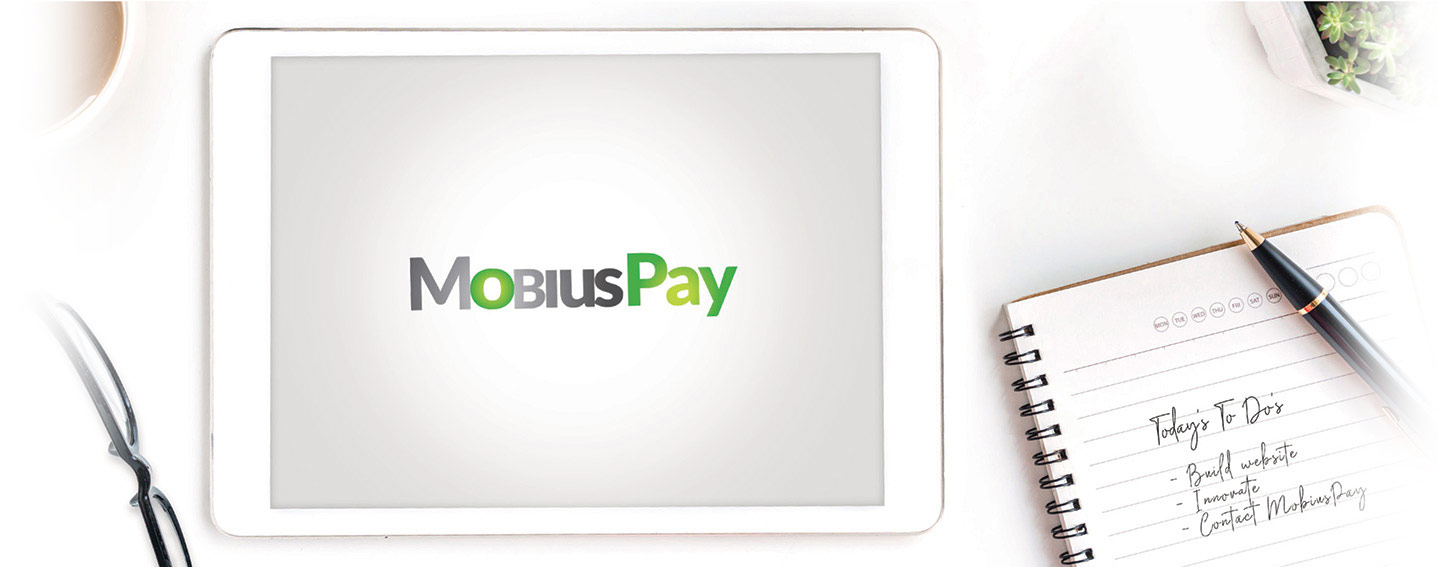 A table with a notepad, ipad, coffee and glasses to show the innovative things you come up with and how you should contact MobiusPay who does Credit Card payment processing supported by people with  years of banking knowledge. 